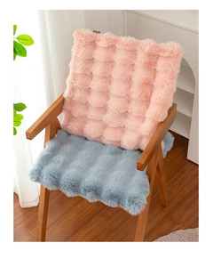 Dettaglio di cuscini in peluche rosa e blu per sedia con trama a griglia e finitura morbida