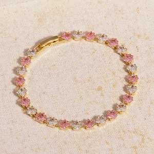 Macro shot of pink and white cubic zirconia stones set in a gold alloy bracelet