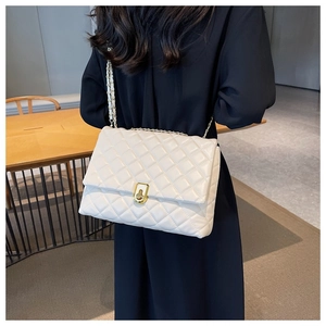 Detail of white quilted PU leather crossbody bag with gold chain and square twist lock