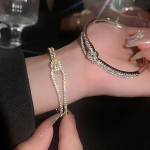 Geometrische zirkonia armband in goud en zilver met kristallen op een zwarte achtergrond