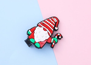 Detail of Christmas gnome hair clip in red, white and green PVC soft rubber material