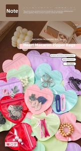 Macro detail of heart-shaped macaron jewelry pouches in multiple pastel colors