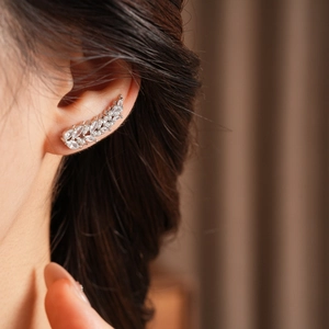 Close-up of a silver wheat ear crawler earring with sparkling cubic zirconia on model
