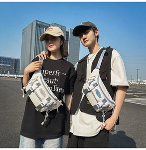 Outdoor lifestyle shot of a cream-colored crossbody bag with multi-pocket utility design