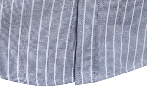 Detailed close-up of blue and white striped shirt hem with premium oxford fabric texture
