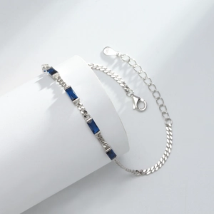 Detail of S925 sterling silver bracelet featuring rectangular blue gemstone on white stand