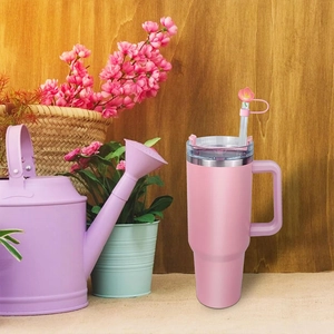 Detail of pink flower straw topper on tumbler with cozy rustic floral background