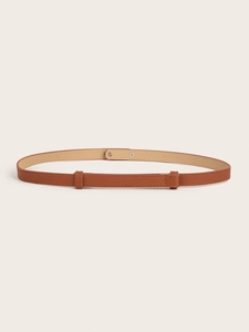 Detail of caramel brown narrow belt showing adjustable metal buckle and Saffiano texture