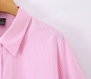 Dettaglio del colletto della camicia a righe rosa e bianche con etichetta Aveloria M