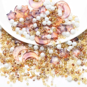 Macro shot of pink moon and star resin beads mixed with gold and pearl DIY craft beads