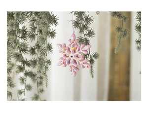 Detailed view of pink snowflake resin ornament with colorful sprinkles on pine branch
