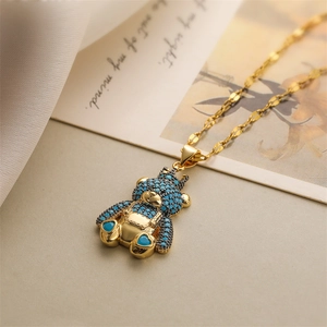 Detailed macro view of a gold bear pendant with blue and black micro-set zircons and crown