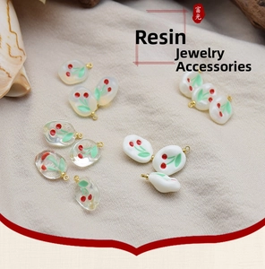 Close-up of resin cherry charms in transparent and matte finishes for DIY jewelry making