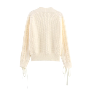 Elegant cream cable knit sweater featuring V-neck design and ribbon bow cuffs on sleeves