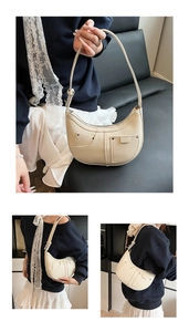 Detail der cremeweißen Hobo-Tasche mit Litchi-Textur und einzigartigem Taschendesign mit Nieten