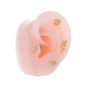 Close-up of gold stainless steel stud earrings set on a pink silicone ear model