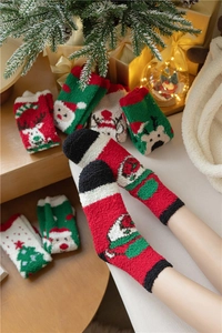 Gros plan de chaussettes de Noël épaisses en polaire corail avec motifs Père Noël et renne