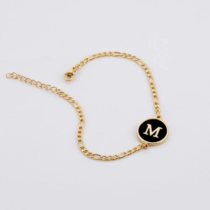 18K gold plated stainless steel Figaro chain bracelet featuring a black letter M charm