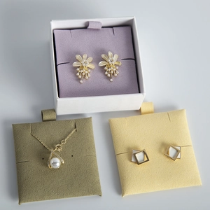 Elegant pearl jewelry set with flower earrings and necklace on velvet display pads