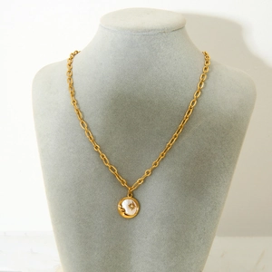 18K gold plated stainless steel necklace with sun and moon shell pendant on display