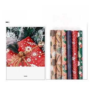 Close-up of vintage kraft Christmas wrapping paper rolls featuring deer and snowflakes