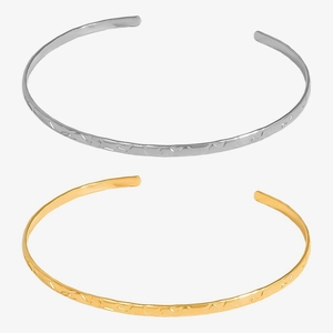 Detail of hammered texture on 18k gold and silver stainless steel open cuff bracelets