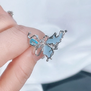 Macro detail of silver butterfly ring with light blue enamel wings and gemstone