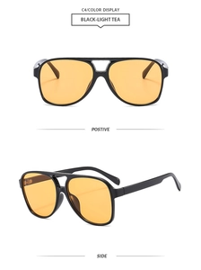 Detail view of classic pilot sunglasses with black frame and light tea lenses