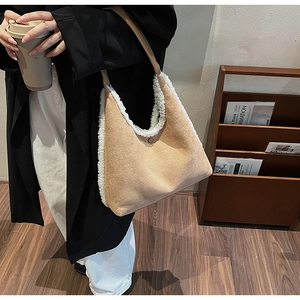 Close-up of khaki suede shoulder bag with soft white faux shearling trim details