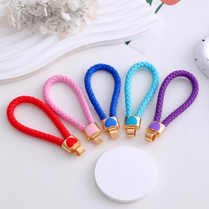 Detail of colorful woven leather keychains with gold heart-shaped metal charms