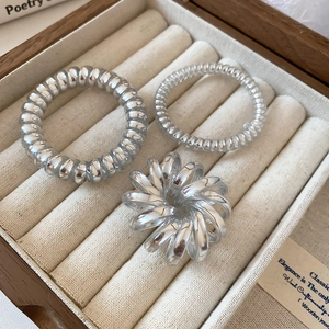 Close-up of spiral telephone wire hair ties in a premium velvet-lined jewelry box