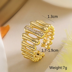 Détail macro d'une bague ouverte irrégulière plaquée or avec structure en zircone