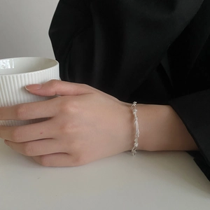 Close-up of minimalist S925 sterling silver twisted chain bracelet on a model's wrist