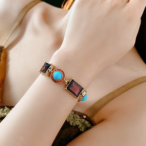 Detail of vintage gold bracelet with purple gemstones and turquoise insets on wrist