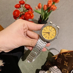 Detail of silver stainless steel watch with yellow square dial and date display window
