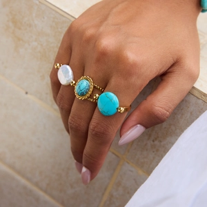 Close-up of bohemian 18K gold plated rings set featuring turquoise and pearl stones