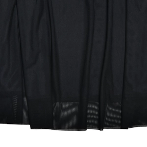 Gros plan sur la texture délicate du tissu en maille noire et l'ourlet de la robe