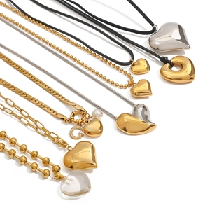 Collection of stainless steel heart pendant necklaces in gold and silver on white background