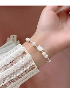 Detailed view of s925 silver cat shell and freshwater pearl bracelet on wrist