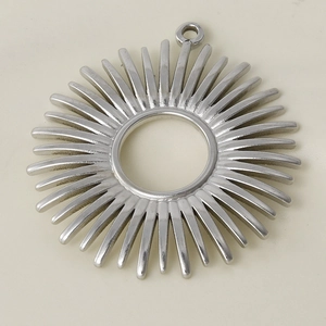 Macro shot of a silver sun-shaped stainless steel pendant with radial gear-like details