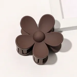 Macro shot of dark brown matte flower hair claw with durable plastic grip teeth