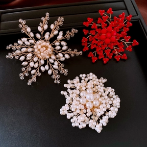 Dettaglio macro della spilla floreale fatta a mano con perle e cristalli su vassoio