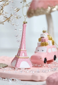 Detail of pink Eiffel Tower and car Christmas ornaments with golden embossed textures