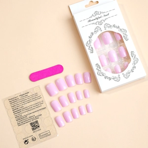 Detail of pink glossy press-on nail kit with 24 tips, file, and adhesive instructions