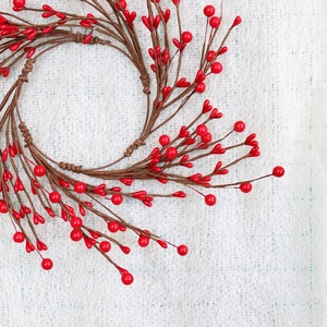 Festive red berry candle ring with glossy artificial berries on brown branches decor