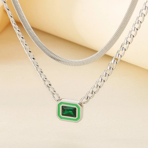 Detail of double-layered silver necklace with emerald-style green stone pendant