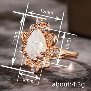 Roségouden ring met peervormige opaal en blauwe stenen in een elegant bladontwerp