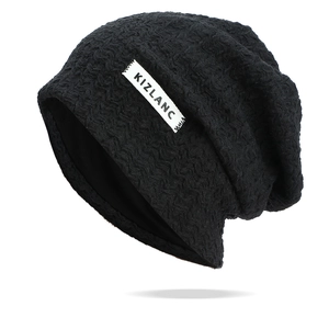Vue détaillée du bonnet slouchy noir texturé avec motif à vagues et écusson blanc