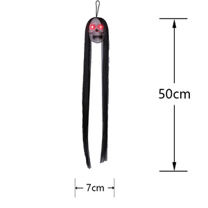 Detailed view of Halloween hanging skull with glowing red eyes and long black fabric veil