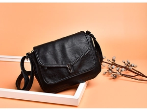 Detail of black faux leather texture with dark silver metal buckle on elegant handbag
